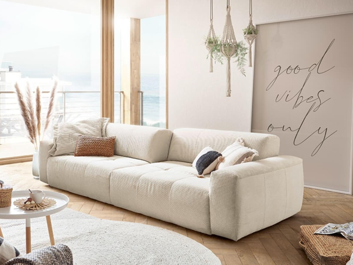 Neutrálne zariadená obývačka s dominantnou sedačkou Urban.